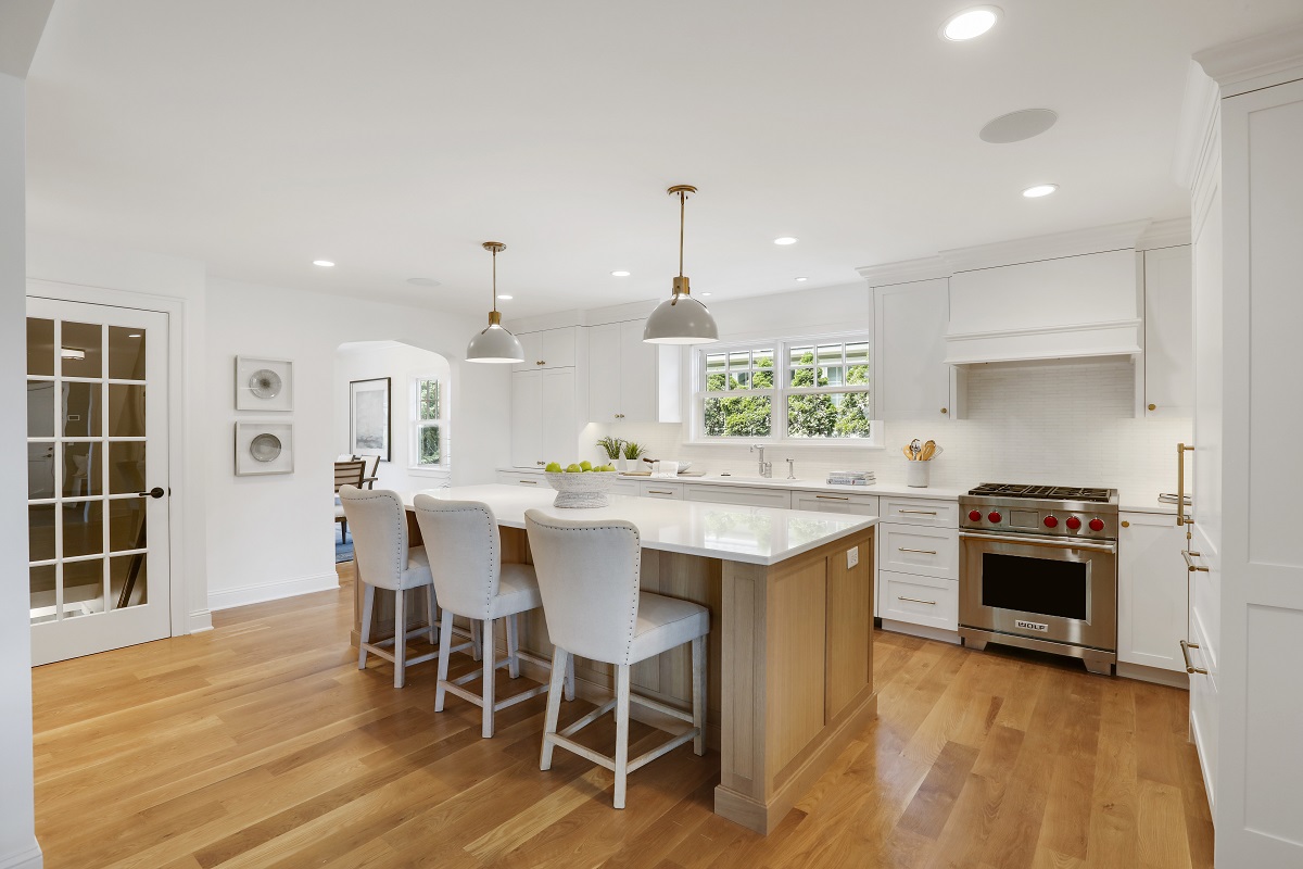 White kitchen island with quartz countertops and pendant lighting