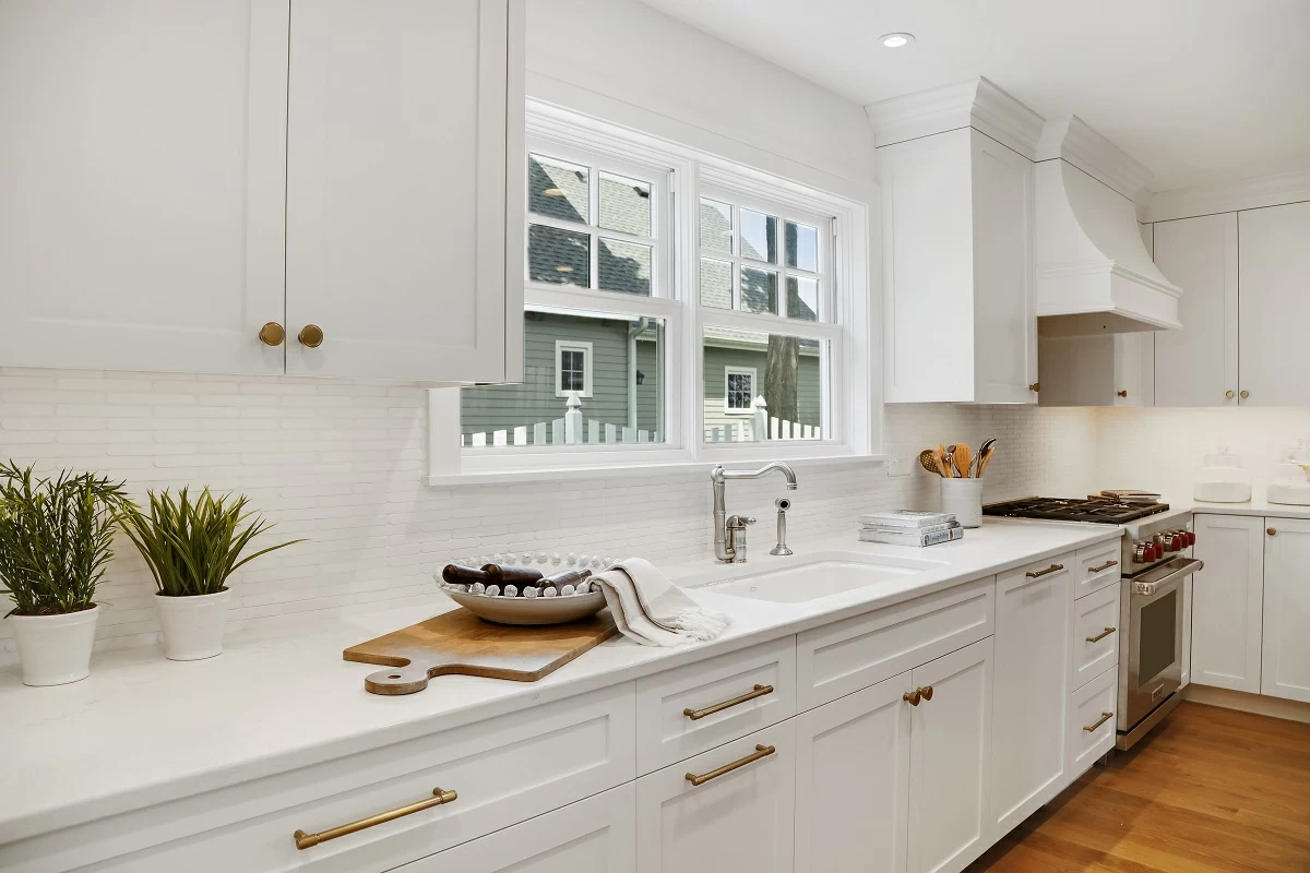 White kitchen island with quartz countertops and pendant lighting