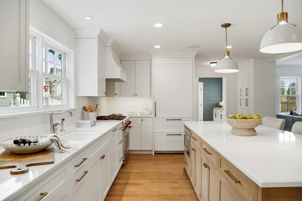 White kitchen island with quartz countertops and pendant lighting