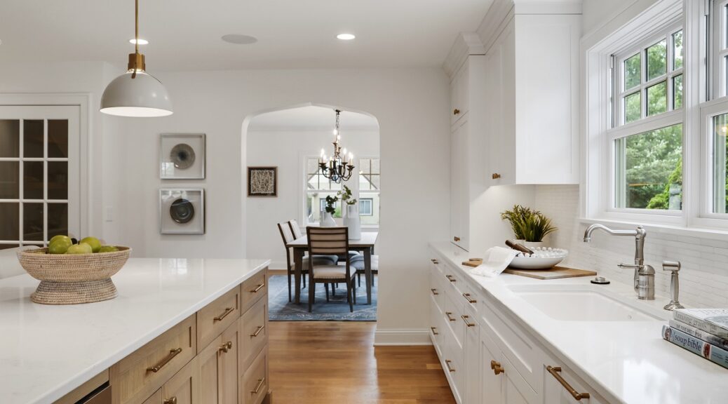 White kitchen island with quartz countertops and pendant lighting