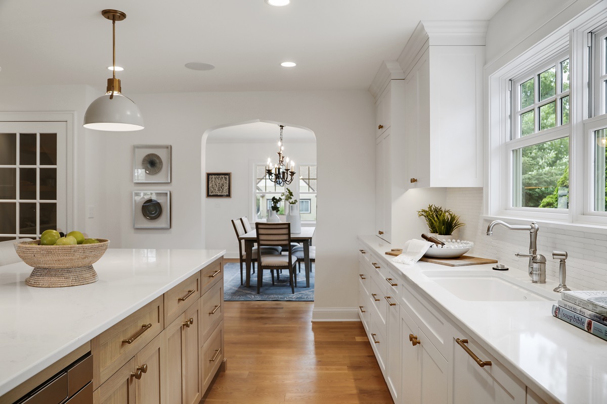 White kitchen island with quartz countertops and pendant lighting